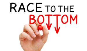 race to the bottom sign concept UCX in commoditized world